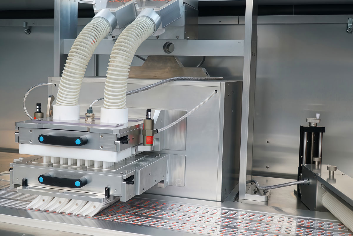 BMR270 Blister Machine - Thermoforming Blister Feeder Close-up of the dedicated blister feeding system for transparent thermoformed packaging on the BMR270 high-speed rotary machine, ensuring accurate and rapid solid dose placement into plastic cavities.