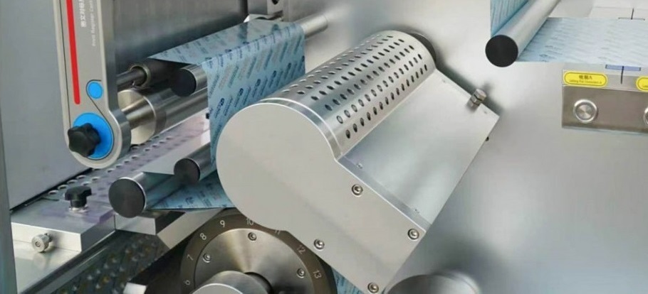 Continuous-motion rotary sealing station using a heated roller on a blister machine